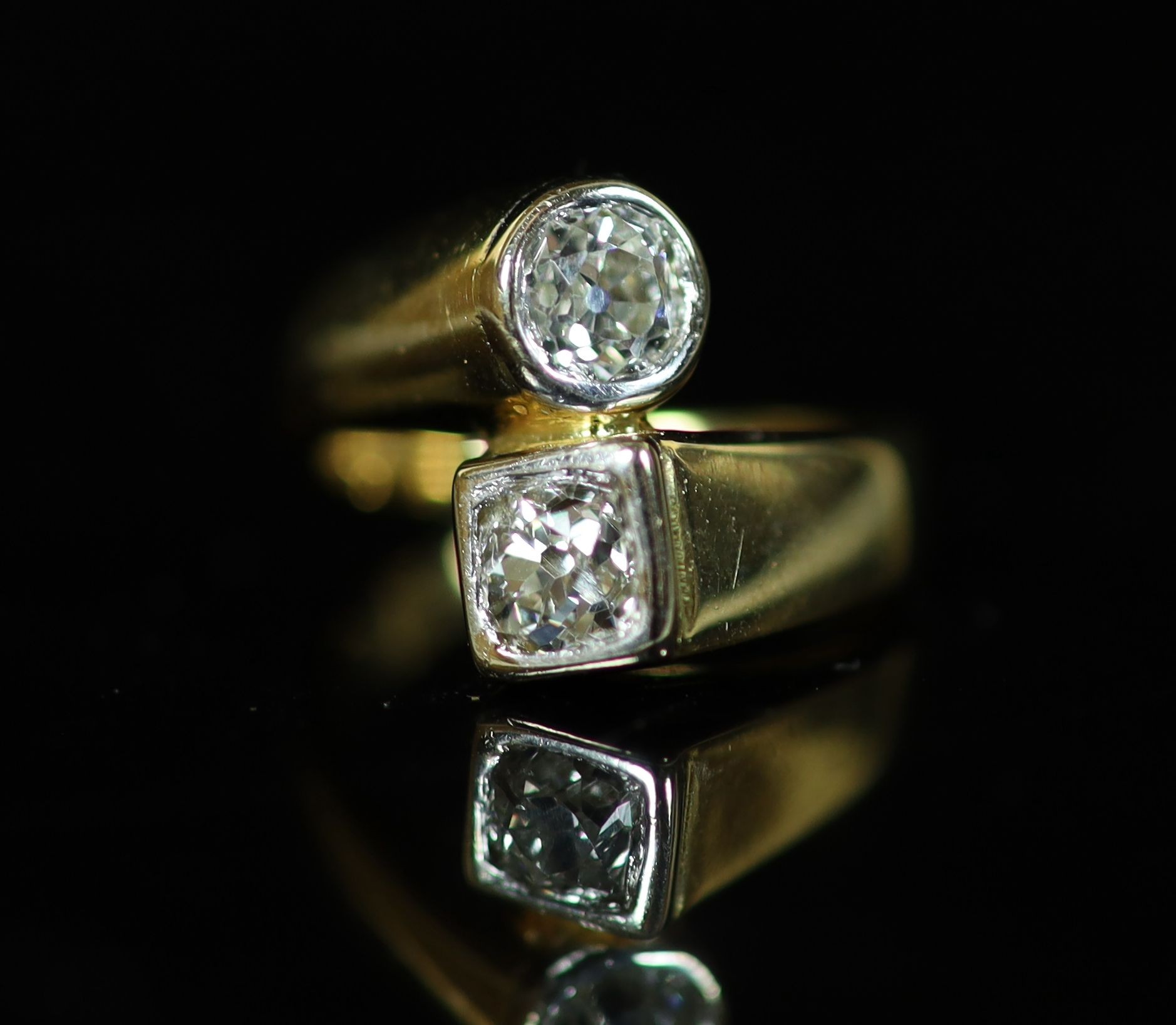 A Continental gold and collet set two stone diamond crossover ring
